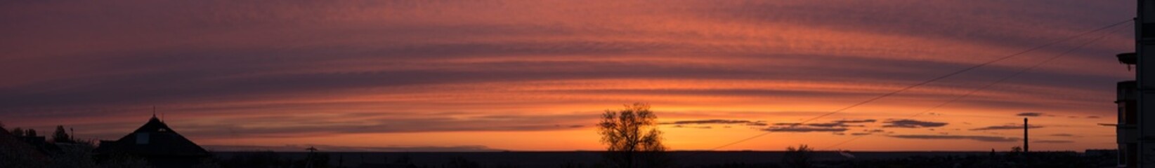 Landscape at sunset. Tragic gloomy sky. Panorama. Crimson twilight.