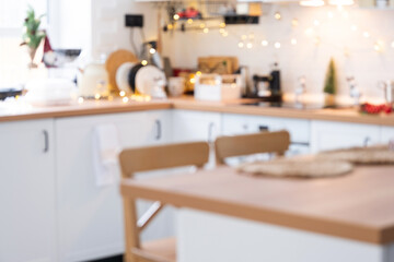 Interior background in a blur of white wooden kitchen of Festive Christmas decor and mess, festive breakfast, white scandi interior. New Year, mood, cozy home