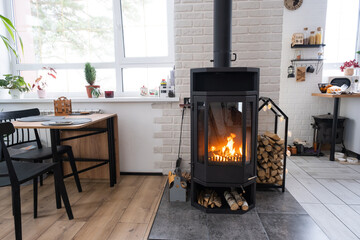 Festive interior of house is decorated for Christmas and New Year in loft style with black stove,...