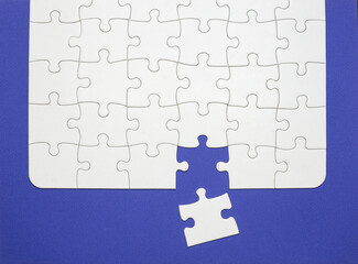 last piece of the white jigsaw, step of the success concept. blue background with space for copy....