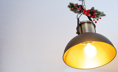 The black lampshade in the industrial loft style is decorated with spruce branches for Christmas...