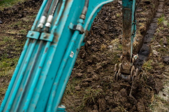 Close up of excavator or digger digging some a soil or clay, industrial concept