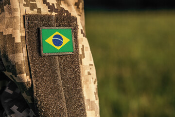 Close up millitary woman or man shoulder arm sleeve with Brazil flag patch. Brazil troops army, soldier camouflage uniform. Armed Forces, empty copy space for text

