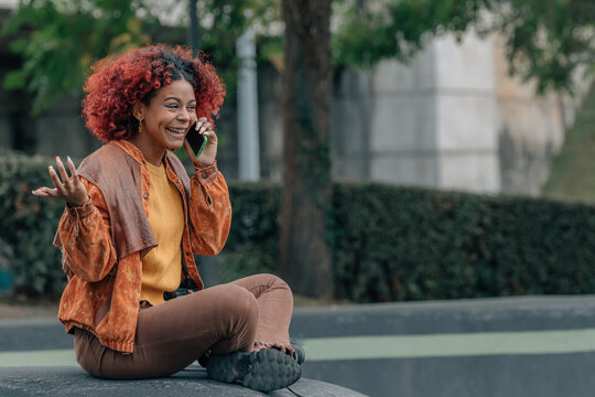 girl talking on mobile phone sitting on the street