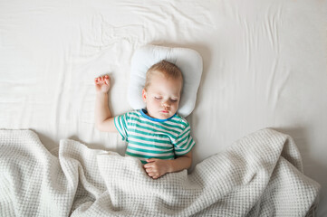 Toddler boy sleeping close-up on bed. Health care concept