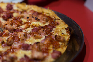 Close-up of a meat, bacon and cheese pizza. Delicious pizza ready to be eaten. Selective focus.  