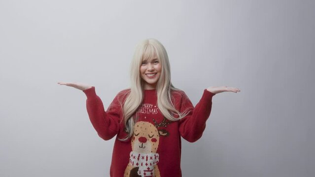 Portrait of happy Caucasian young woman in Christmas sweater over white background