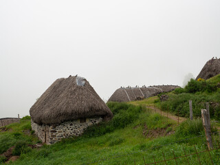 Vistas de casas típicas en fila, en la Braña de Pornacal, de Asturias, con techo de paja en...