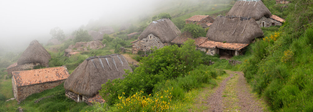 Vistas panor&aacute;micas de un pueblo t&iacute;pico rural en la Bra&ntilde;a de Pornacal, de Asturias, con techos de paja en un d&iacute;a nublado de verano en Espa&ntilde;a, 2021