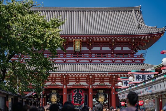 Sensoji temple in Asakusa, Tokyo Japan with tourists exploring it under a clear blue ksy