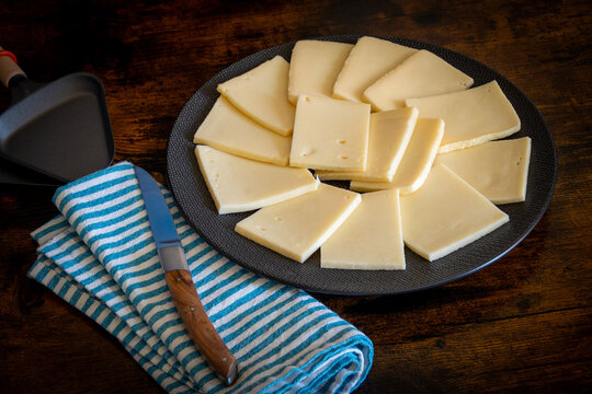assiette de tranches de fromage à raclette en gros plan	