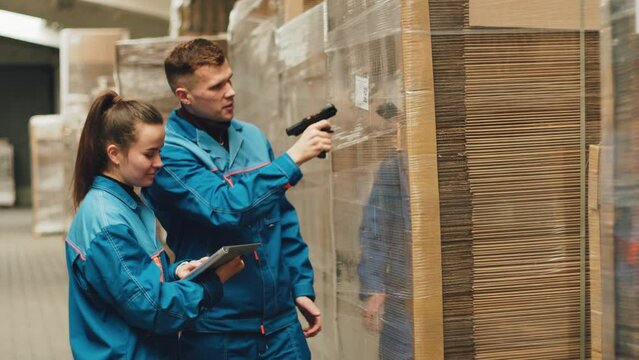 Cardboard industry. Packaging plant engineers scans a barcode in a warehouse.