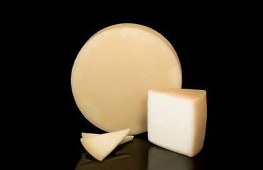 A cheese with a texture to its rind isolated on a black background next to a wedge and slices of cheese.