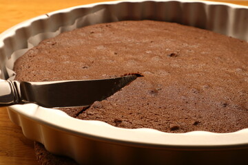 Homemade sticky chocolate cake. Traditional and popular Swedish pastry. Metal knife. Close up and isolated.