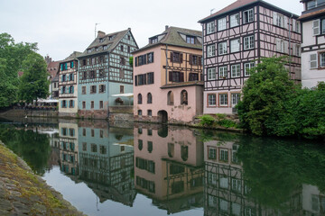 Fototapeta na wymiar Colored houses in a French village along a canal in the Alsace area