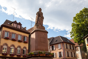 Fototapeta premium houses of a village in Alsace with a castle in the background and some green mountains.
