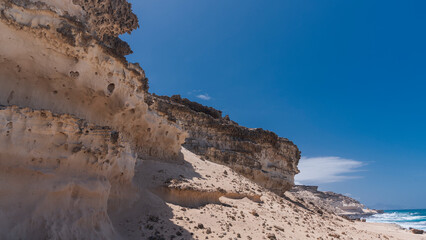Fototapeta na wymiar Coastal desert landscape made of high, barren, hard rocky plateaus, West Coast, Fuerteventura, Spain