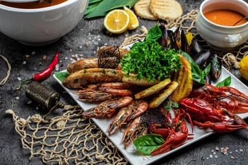 set of seafood shrimp, fish, crayfish, mussels and soup on a dark background. Restaurant menu, dieting, cookbook recipe top view