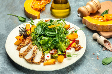 fresh salad with grilled chicken fillet, feta cheese, caramelized pumpkin, superfood keto diet concept. Healthy, clean eating, top view