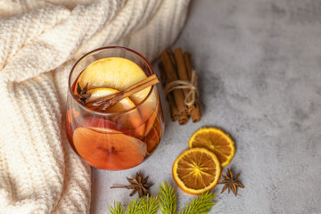 A glass of hot Christmas mulled wine with spices and fresh fruit pieces. Traditional winter drink