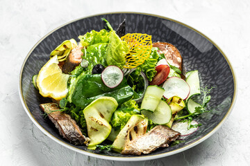 salad with smoked red fish with fresh vegetables, lettuce leaves on a white background, Restaurant menu, dieting, cookbook recipe top view