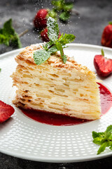 Layered baked pie with creamy vanilla swith cream, apples and strawberry jam decorated mint....