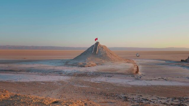 Red flag on the top point of deserted tunisian lake Chott el Djerid. Very arid conditions in Africa almost dried lake.