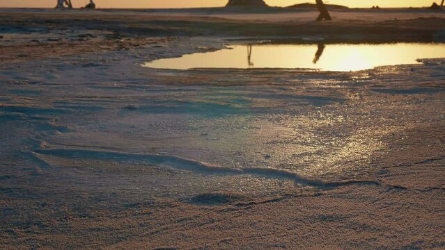 Sunset light reflected in water remains of lake Chott el Djerid. Very arid conditions in Africa almost dried lake.