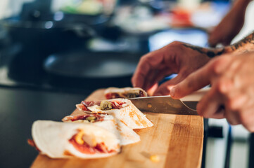 Burrito cut on pieces and served on a wooden board for breakfast