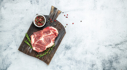 Pork steak with rosemary and pepper on a light background. Long banner format. top view