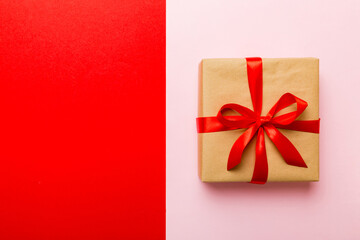 holiday brown paper present tied red ribbon bow top view with copy space. Flat lay holiday background. Birthday or christmas present. Christmas gift box concept with copy space