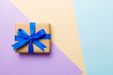 holiday handmade paper present tied blue ribbon bow top view with copy space. Flat lay holiday background. Birthday or christmas present. Christmas gift box concept with copy space