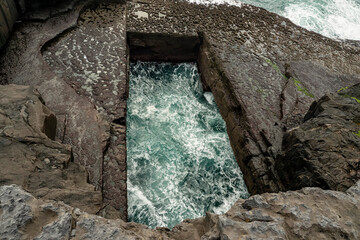 View on Poll na bPéist Wormhole, Inishmore, Aran Island. Ireland. Famous and popular tourist...