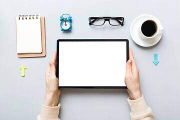 Close up image woman hands holding digital tablet with blank copy space screen for your text message or promotional content om table with cup of coffee. hands of a woman holding blank tablet device
