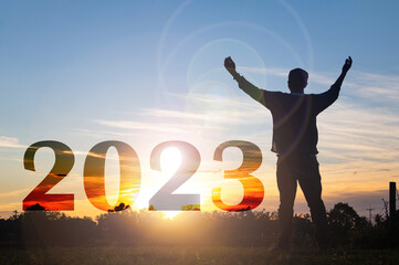 Happy new year Silhouette sunset background.A man standing next to 2023.new year,success,2023, Photo Silhouette and new year  concept idea.