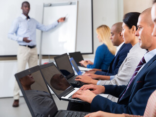 Obraz premium conference of international financial managers with laptop in white room