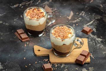 Dessert three chocolate in a glass jar on a wooden board. Food recipe background. Close up