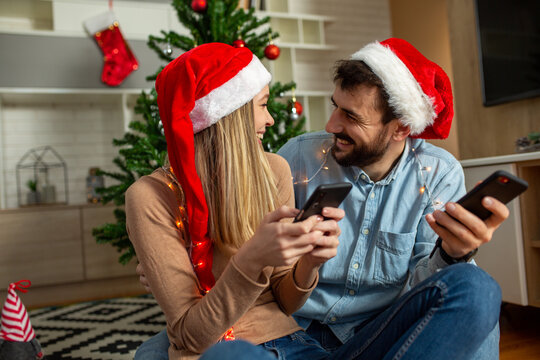 Christmas couple using phone at home