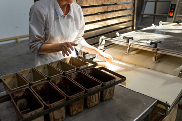 Empty metal molds for baking bread on the table in front of the baker. Industrial production of...