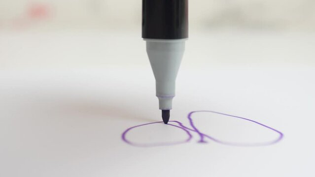 Purple marker draws on a white sheet