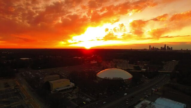 Aerial Panning Descending Shot Of Bojangles Coliseum Arena In Modern City Under Orange Cloudy Sky At Sunset - Charlotte, North Carolina