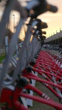 Vertical shot of rack of red sharing bikes in city