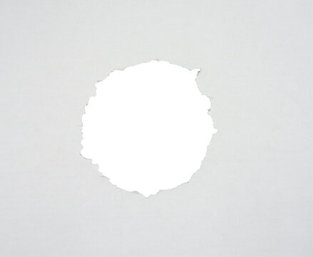 Torn paper with the curled ripped sides. a round black hole of torn on the white paper. realistic torn paper with the ripped edges for copy space and text.