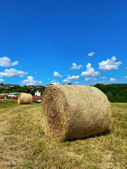 Hay bale stack on the field after harvest with blue sky