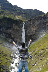 Traveler guy standing rare view both arms stretched enjoying mesmerizing waterfall view