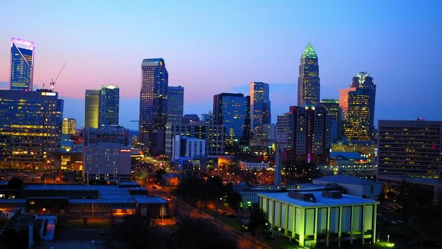 Aerial Panning Shot Of Sparkling Modern Buildings In Downtown Against Cloudy Sky At Dusk - Charlotte, North Carolina