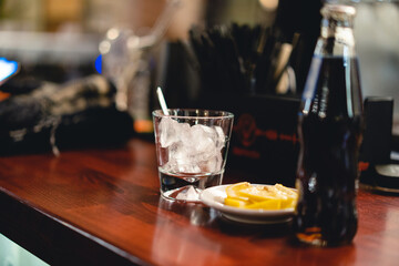 an alcoholic drink with ice is served by the bartender at the bar