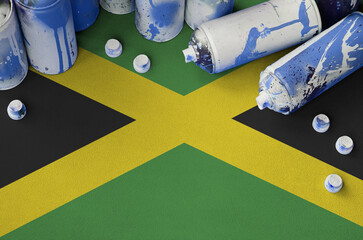 Jamaica flag and few used aerosol spray cans for graffiti painting. Street art culture concept