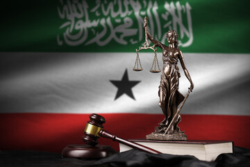Somaliland flag with statue of lady justice, constitution and judge hammer on black drapery....