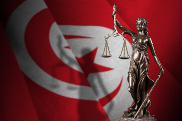 Tunisia flag with statue of lady justice and judicial scales in dark room. Concept of judgement and...